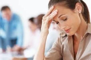 Pregnant women with headache sitting holding head