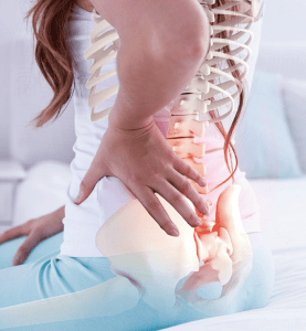 Female holding back in pain because of sciatica pregnancy