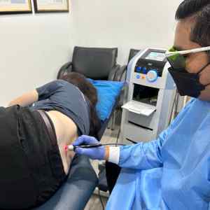 Physiotherapists treating female with back pain in Kuala Lumpur with High Intensity Laser Therapy (HILT)
